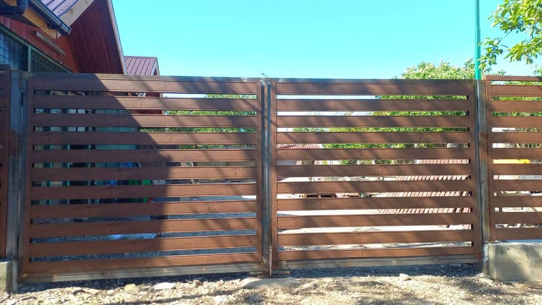 Poartă și gard metalic cu lamele orizontale, finisaj lemn