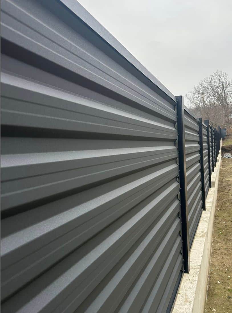 Panouri metalice tip jaluzea montate pe stâlpi, în perspectivă