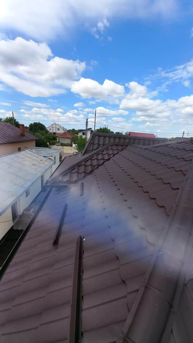 Acoperiș din țiglă metalică maro pe o casă unifamilială