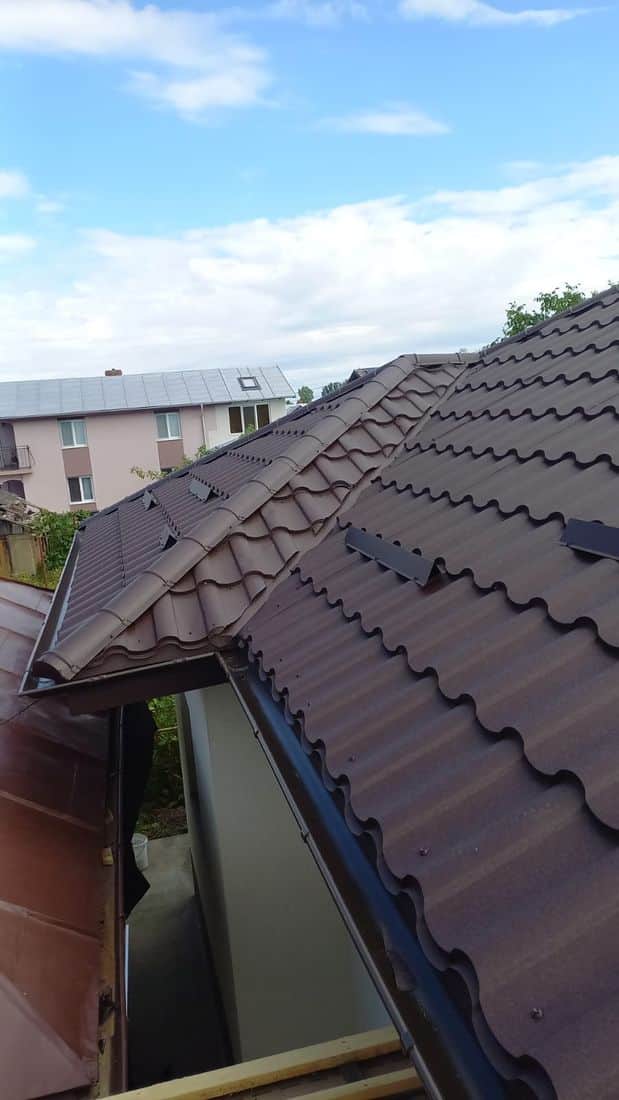 Acoperiș maro din țiglă metalică, cu lucarnă